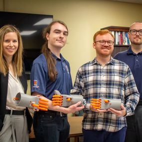Members of the Kassel Hand research team holding 3D printed models of a mechanical hand