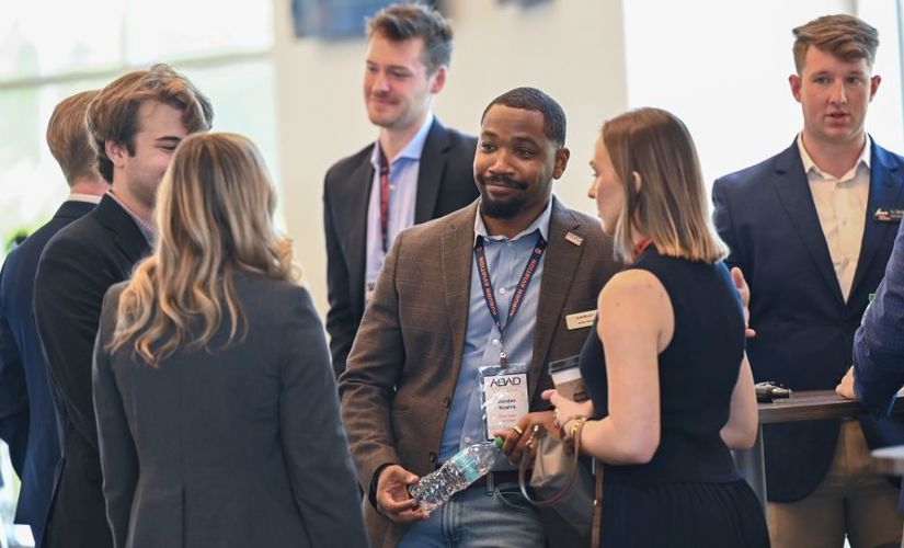four people at a reception standing together and talking 