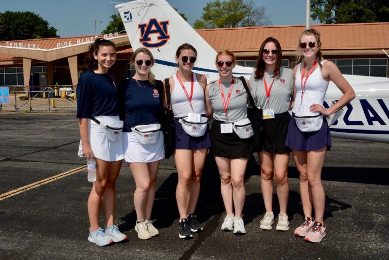The War Eagle Women stand in front of an Auburn plane during the 2022 Air Race Classic