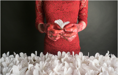 woman in red dress holding white flowers