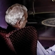 Man dozing in purple chair with a record player in background and couples dancing